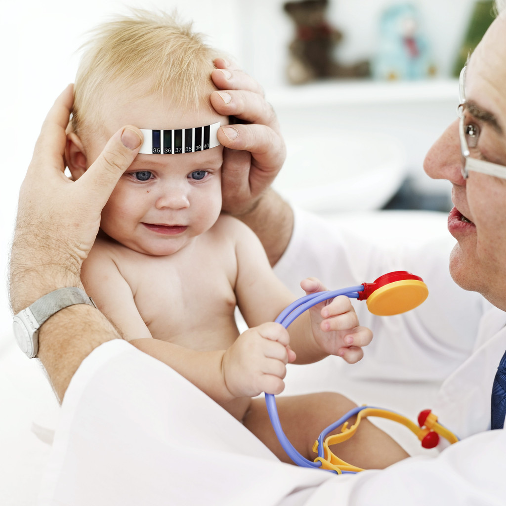 Doctor Applying a Thermometer to a Baby's (12-18) Forehead