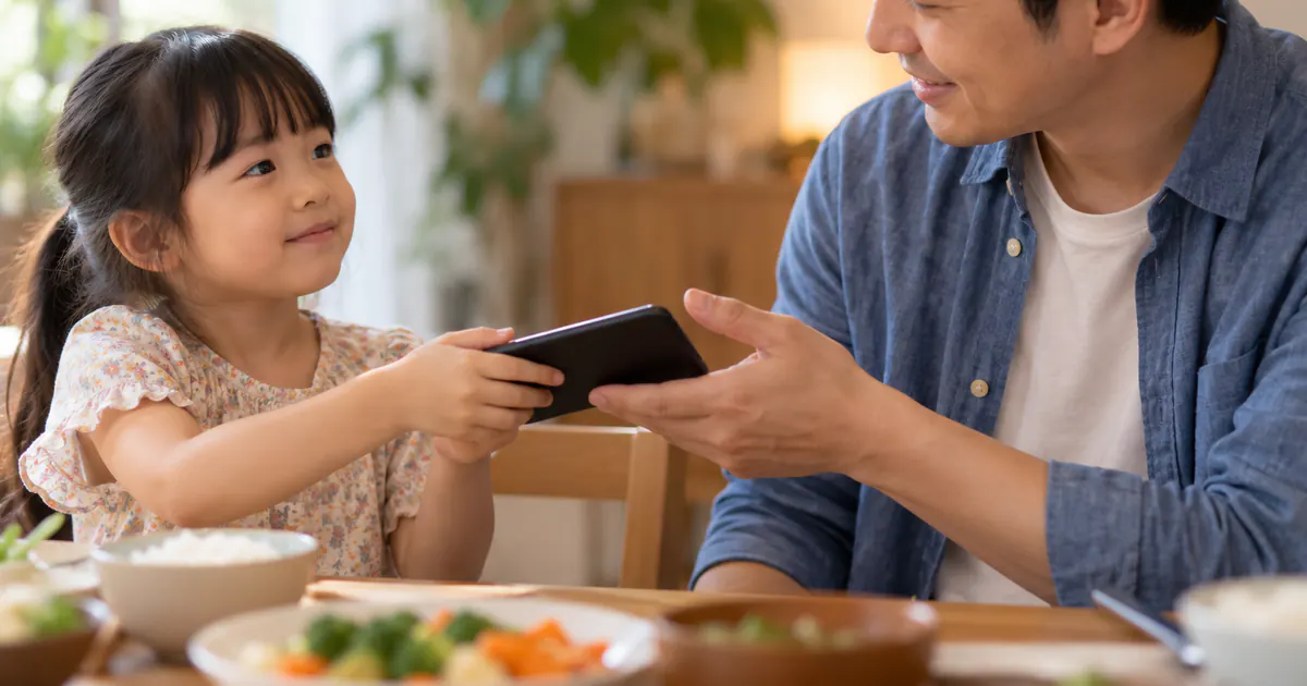 Trẻ bình tĩnh đưa điện thoại cho cha trước bữa ăn theo lộ trình giảm màn hình