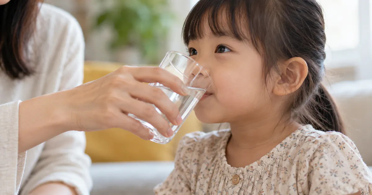 Người chăm sóc cho trẻ uống nước để hỗ trợ tiêu hóa