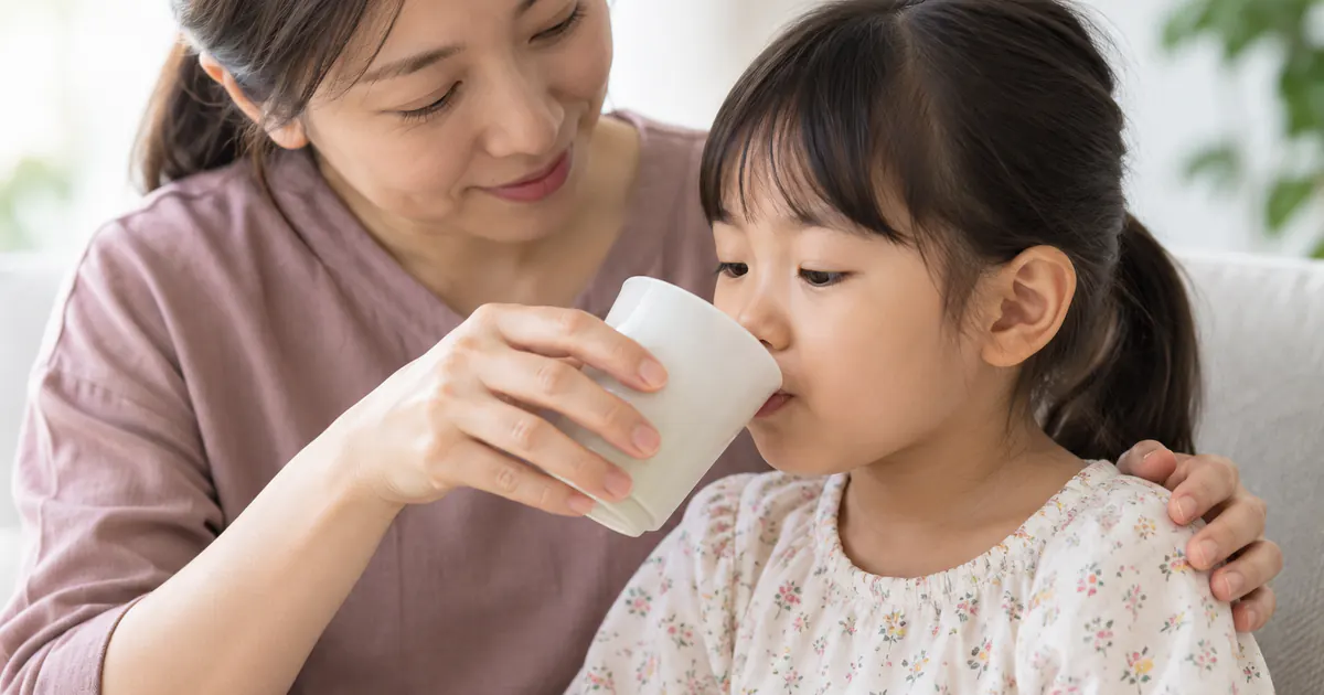 Cha mẹ cho trẻ đau miệng uống từng ngụm nước mát bằng cốc nhỏ
