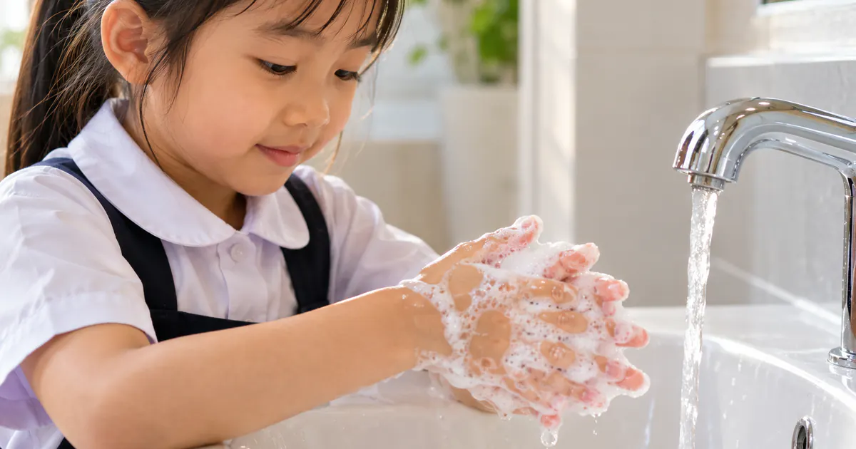 Bàn tay trẻ được chà kỹ bằng xà phòng sau khi đi vệ sinh