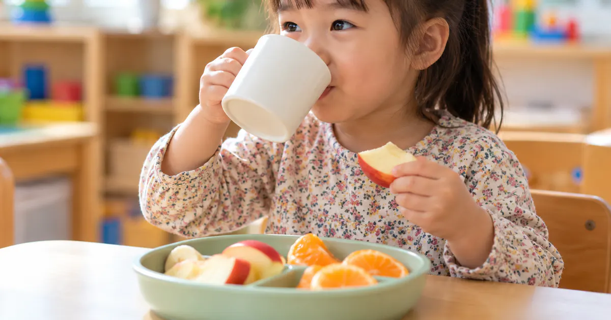 Trẻ ăn trái cây và uống nước để hỗ trợ làm mềm phân