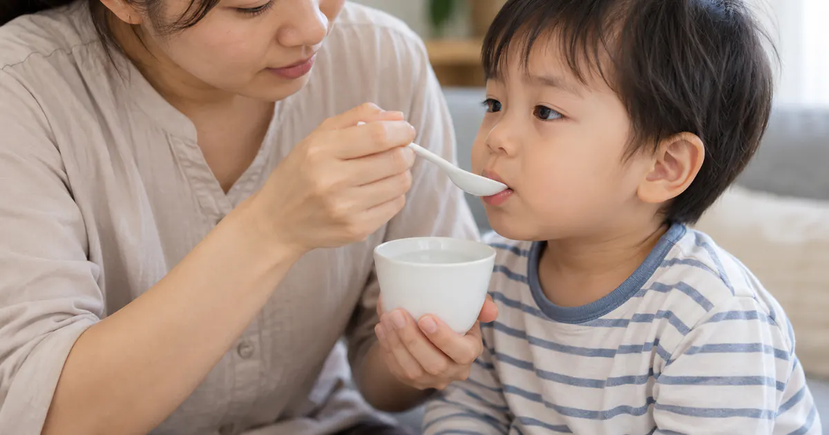 Người chăm sóc cho trẻ tỉnh táo uống từng ngụm dung dịch bù nước